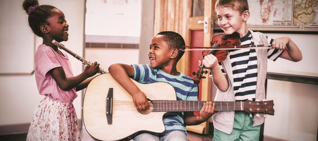  children playing musical instruments in classroom at school