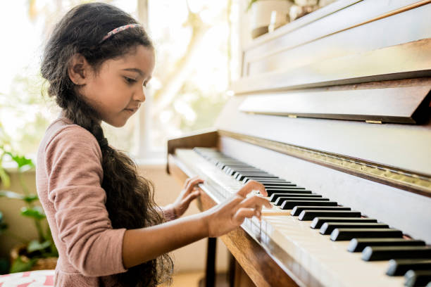 A girl playing a piano, representing the continuation of piano music into the 21st century.