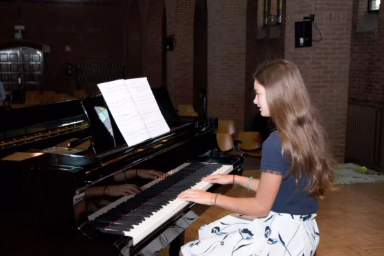 girl playing piano in a church and singing