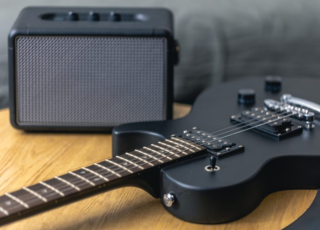 Black electric guitar and speaker close-up. Guitar amplifier, musical equipment. Guitar electric rock background. Use a Metronome for Timing