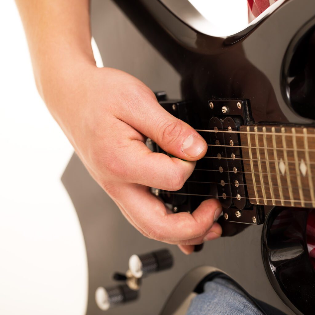 electric guitar chords learning by young musician holding electronic guitar