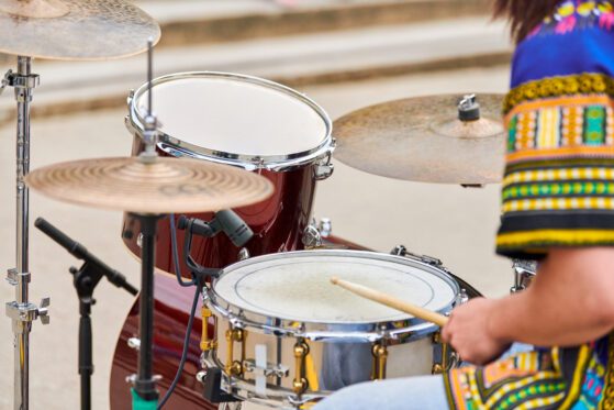 Drummer playing musical percussion instrument drums with sticks