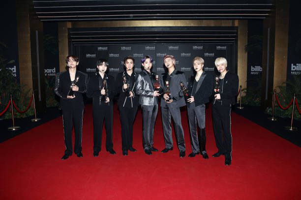 BTS holding trophies on the red carpet at the Billboard Music Awards