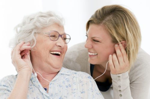 Music therapist playing guitar for elderly patients.