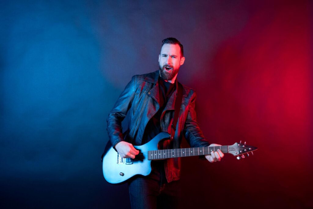 Confident guitarist practicing with metronome in background improving timing and hand synchronization on guitar