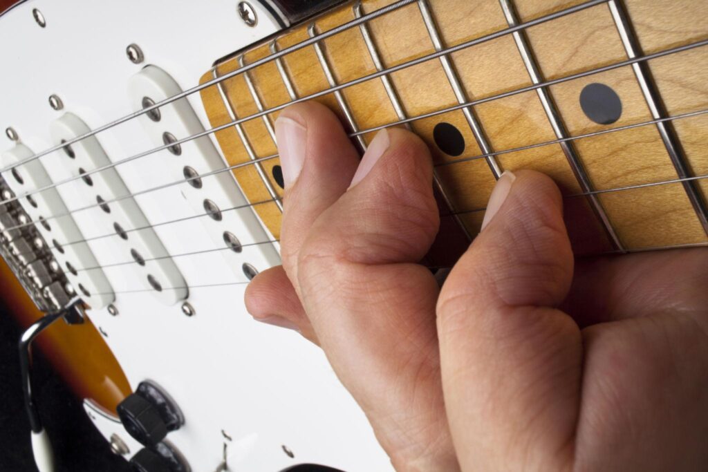 Close-up of fingers playing notes on an electric guitar fretboard, demonstrating lead guitar technique and finger positioning for worship guitar playing in “How to Play Lead Guitar in a Worship Band.”