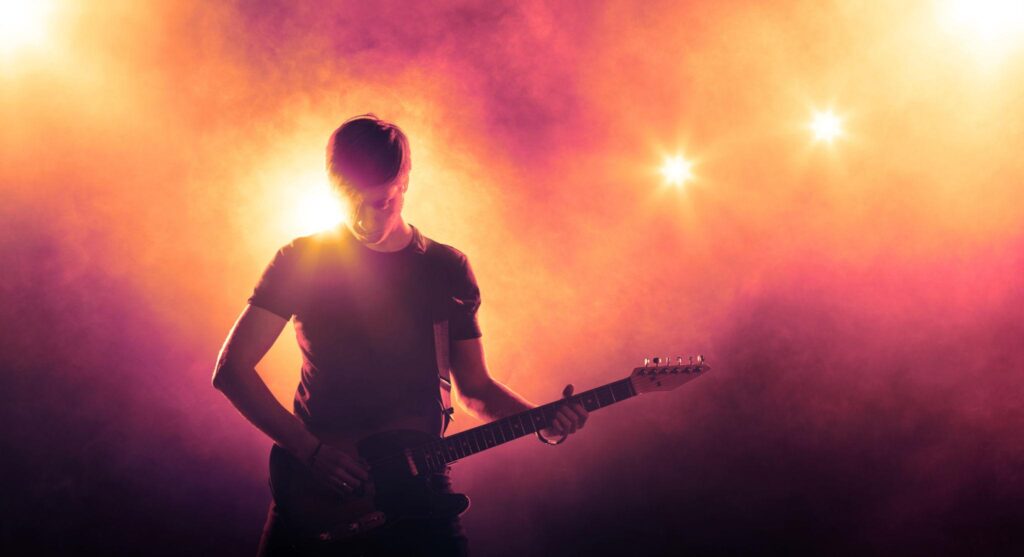 Why Many Guitarists Have Great Speed but Poor Timing — guitarist practicing fast electric guitar solos in a dark music studio.