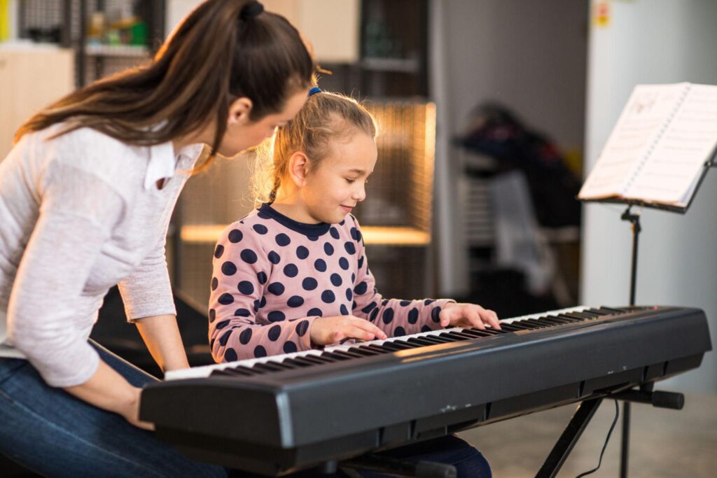 "Piano student studying sheet music and practicing at a piano, demonstrating preparation and focus to overcome piano performance anxiety."