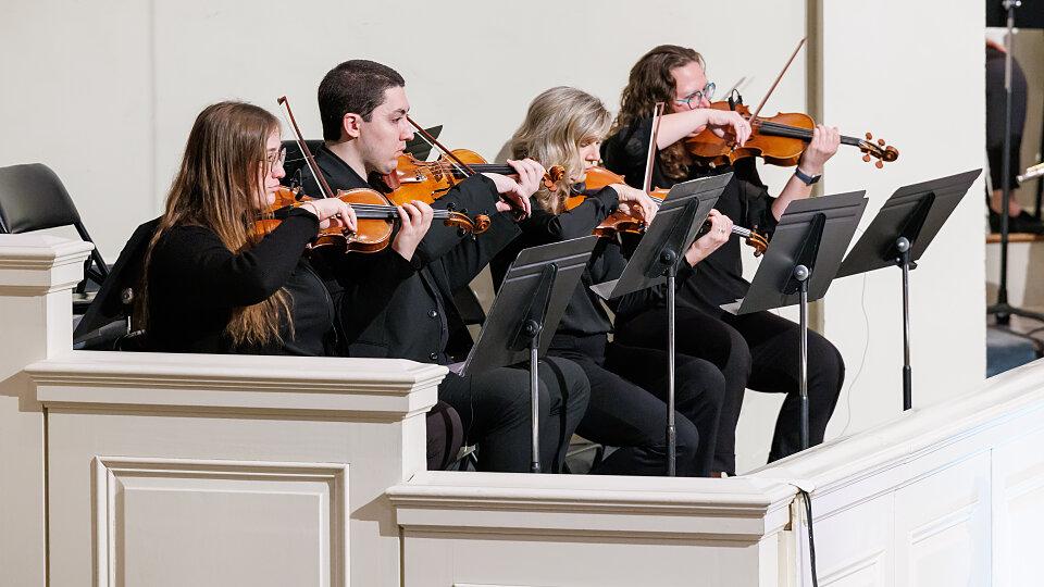 Violinist performing emotional worship music during a church praise and worship event.