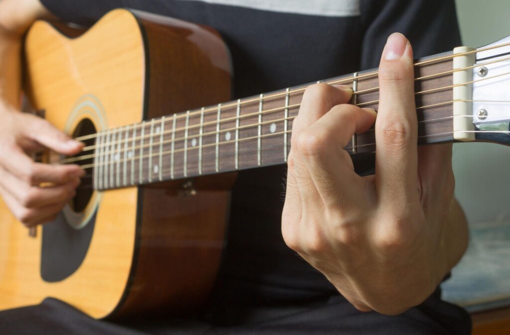 Practising guitar chord changes to develop steady rhythm and accurate timing